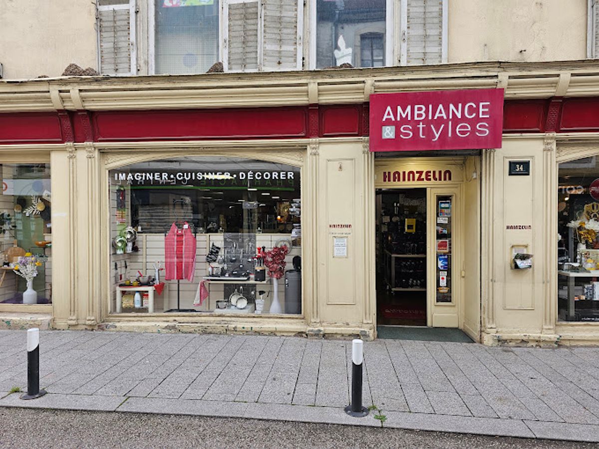 Plaid en grosse maille, coussins en lin lavé et linge de maison en coton bio posés sur un canapé clair