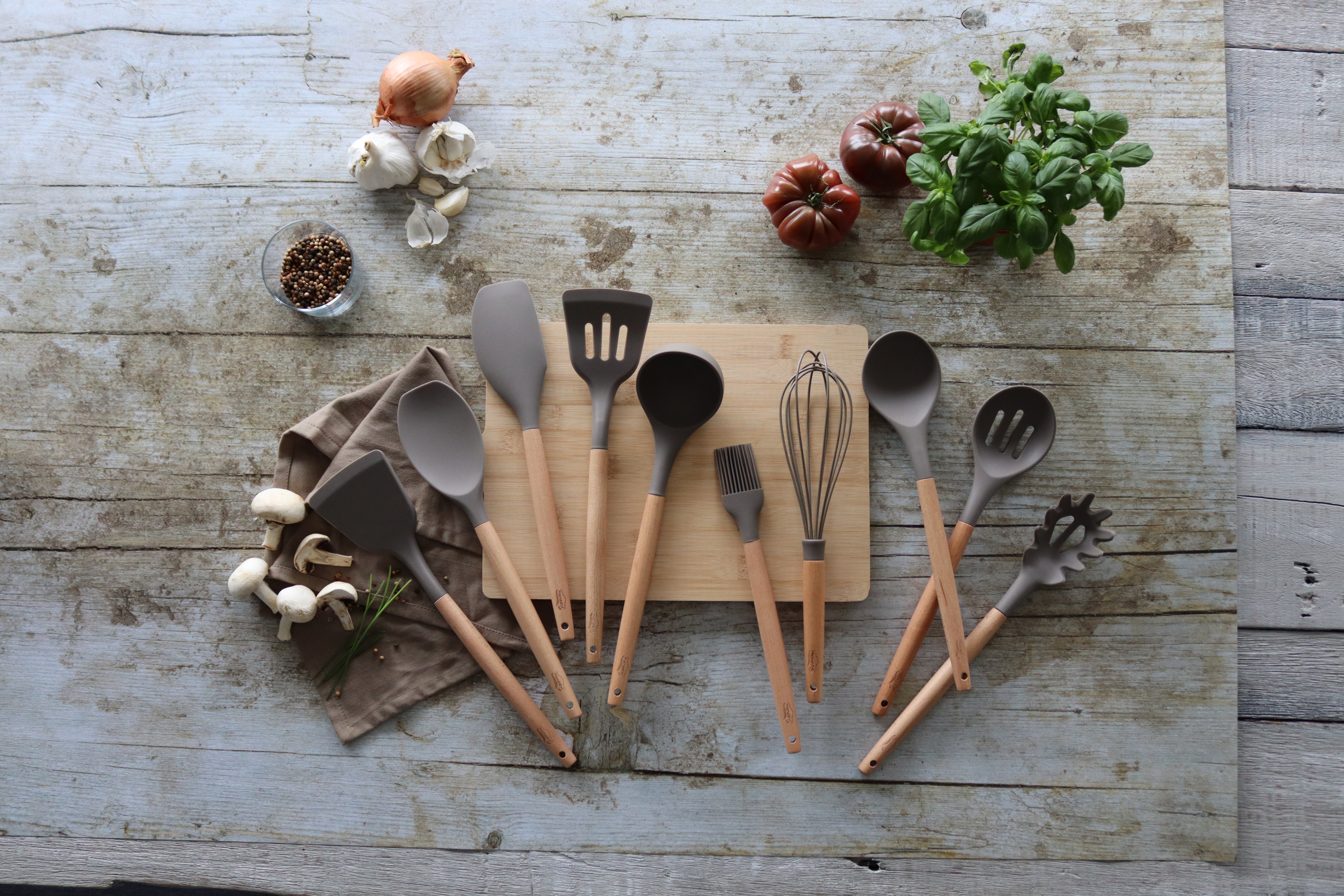 Idées cadeaux pour une cuisine équipée : ustensiles durables et bocaux en verre posés sur un plan de travail
