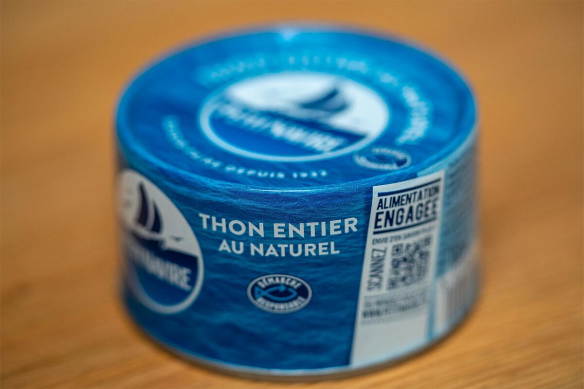Boîtes de thon en conserve alignées sur une étagère de supermarché