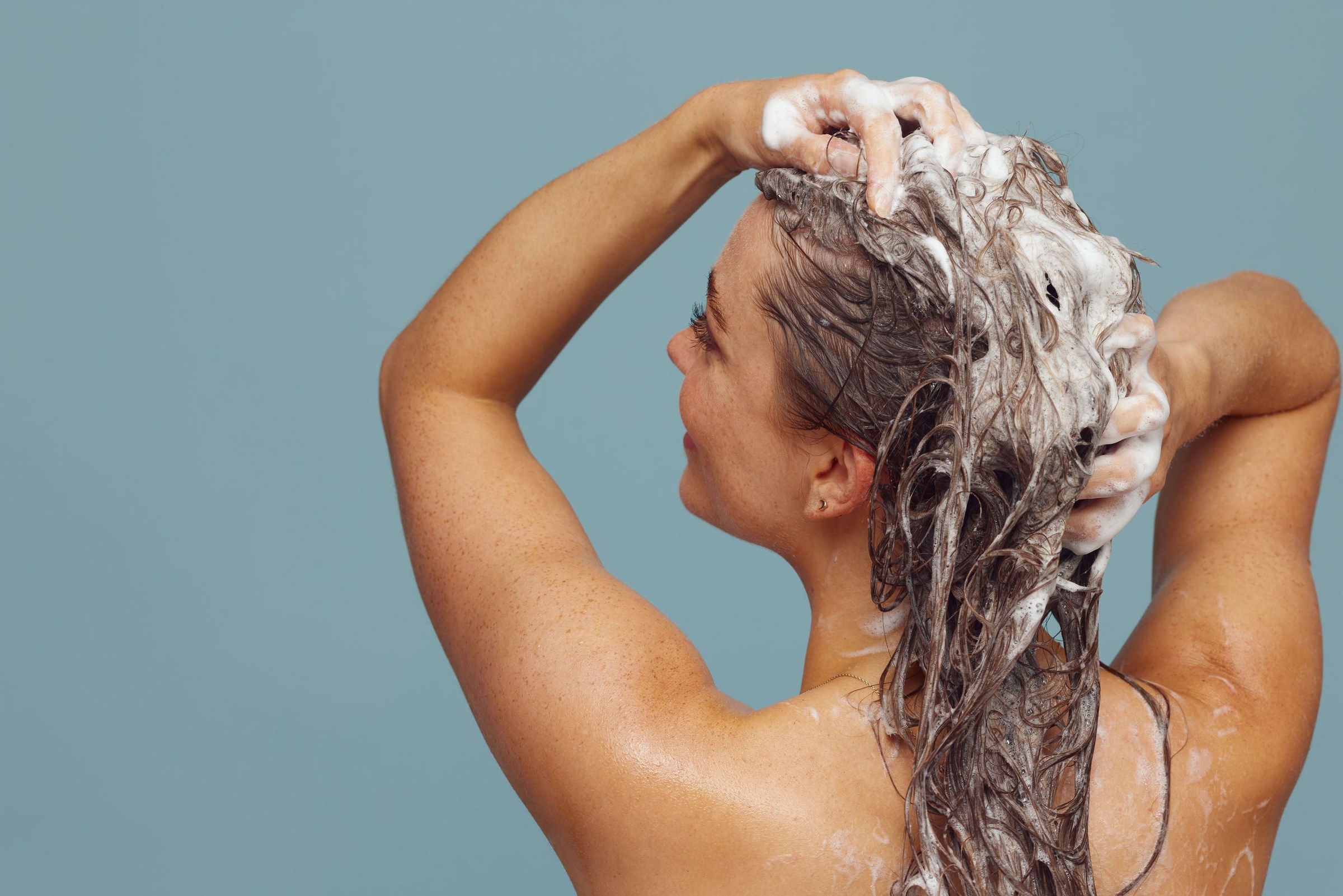 Flacon de shampoing posé dans une salle de bains lumineuse